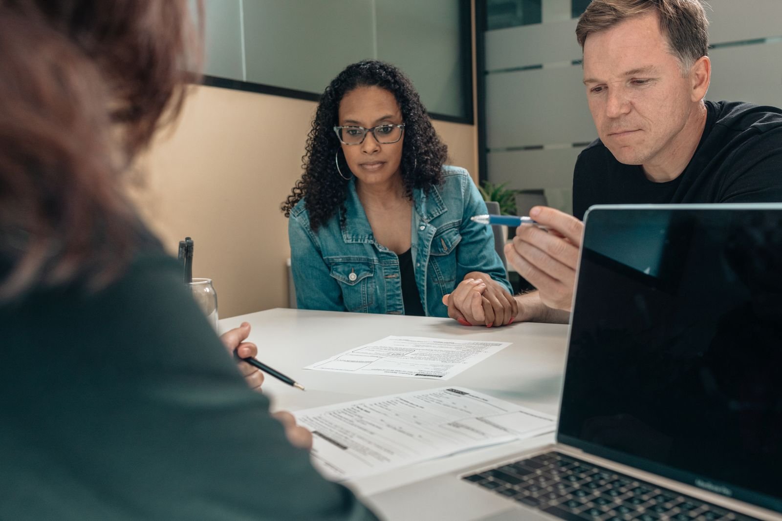 Pareja revisando documentos con su asesora financiera