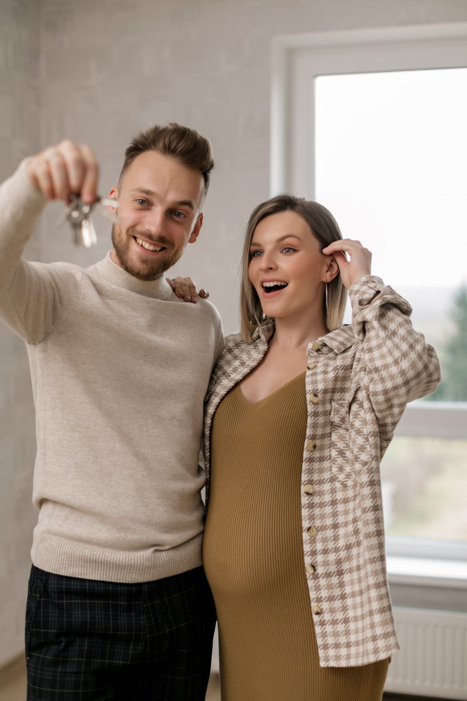 Pareja sonriente con las llaves de su nueva vivienda
